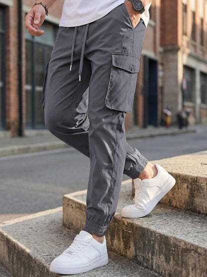 Homixa Belvora men's cargo joggers with drawstring waist, flap pockets, and tapered cuffs, shown in a casual fit.