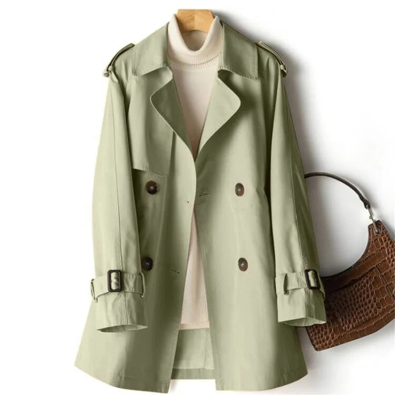 Sweet Emily trench coat by Jack Hafford, featuring classic beige fabric, double-breasted design, and belt, displayed on a hanger.