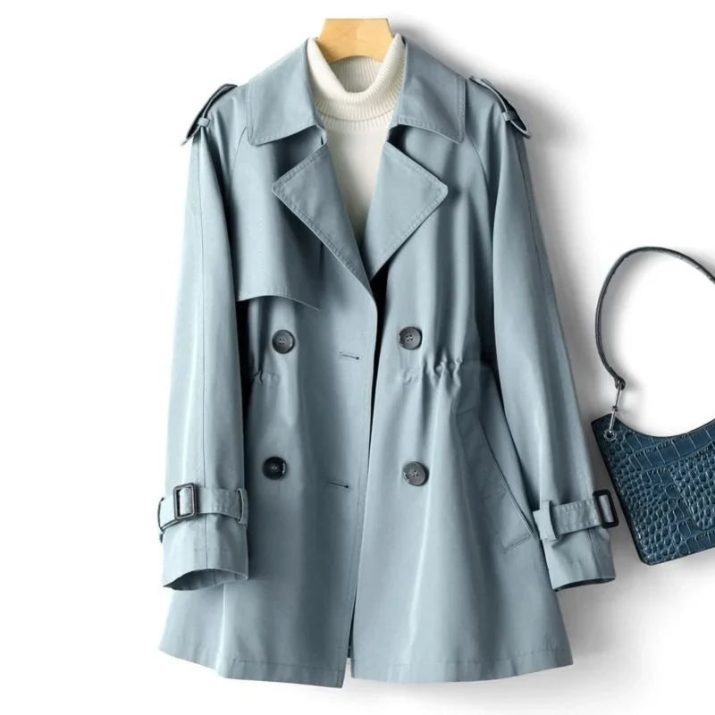 Sweet Emily trench coat by Jack Hafford, shown in beige fabric with classic double-breasted design and belt at waist.