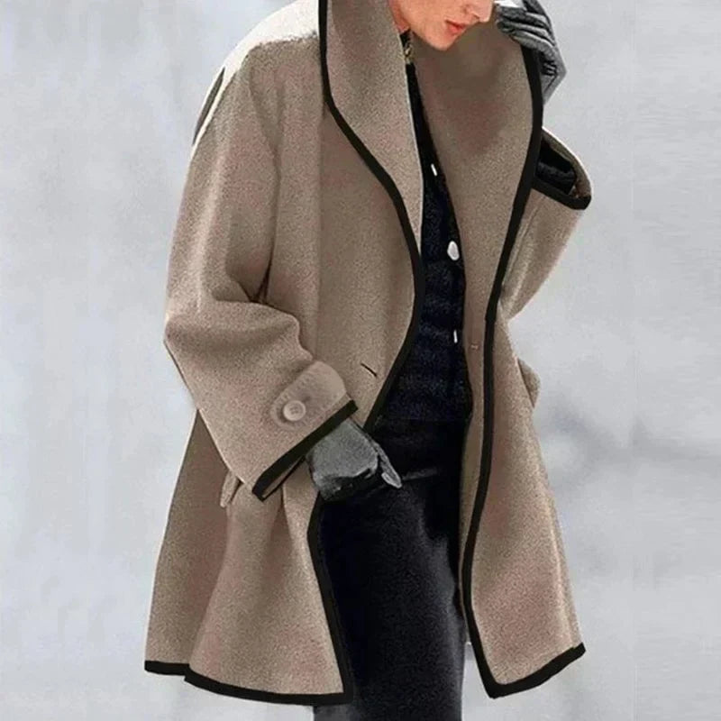 Homixa Agnes women's merino wool trench coat with statement collar, contrast trim, and buttoned cuffs, shown in a stylish profile view.