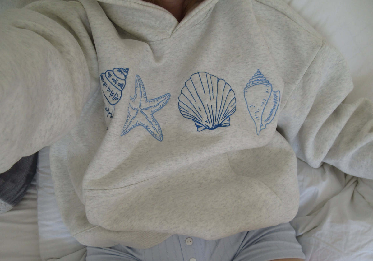 Women's Seashell Print Hoodie by Lunirel featuring a soft fabric and a stylish seashell pattern on the front.