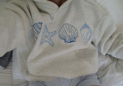 Women's Seashell Print Hoodie by Lunirel featuring a soft fabric and a stylish seashell pattern on the front.