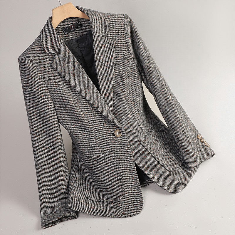 Gray Margot Wool Blazer by Jack Hafford hanging on a wooden hanger, showcasing a tailored, classic design.