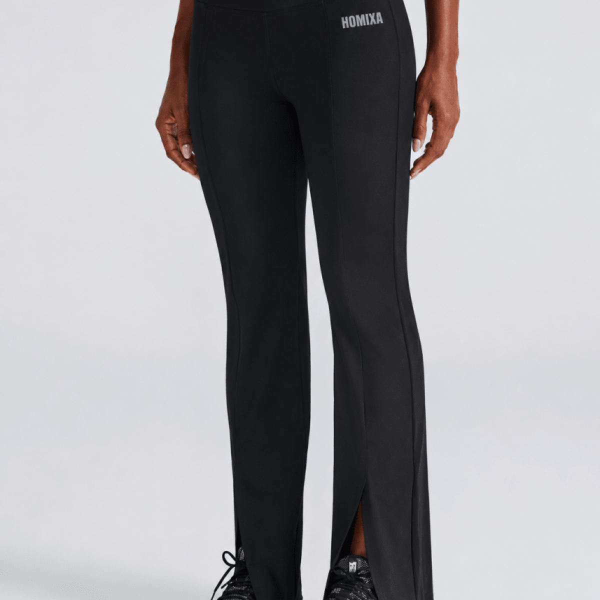 Black Homixa split flare women's sports trousers shown on a model, featuring a fitted waistband and stylish flare legs.