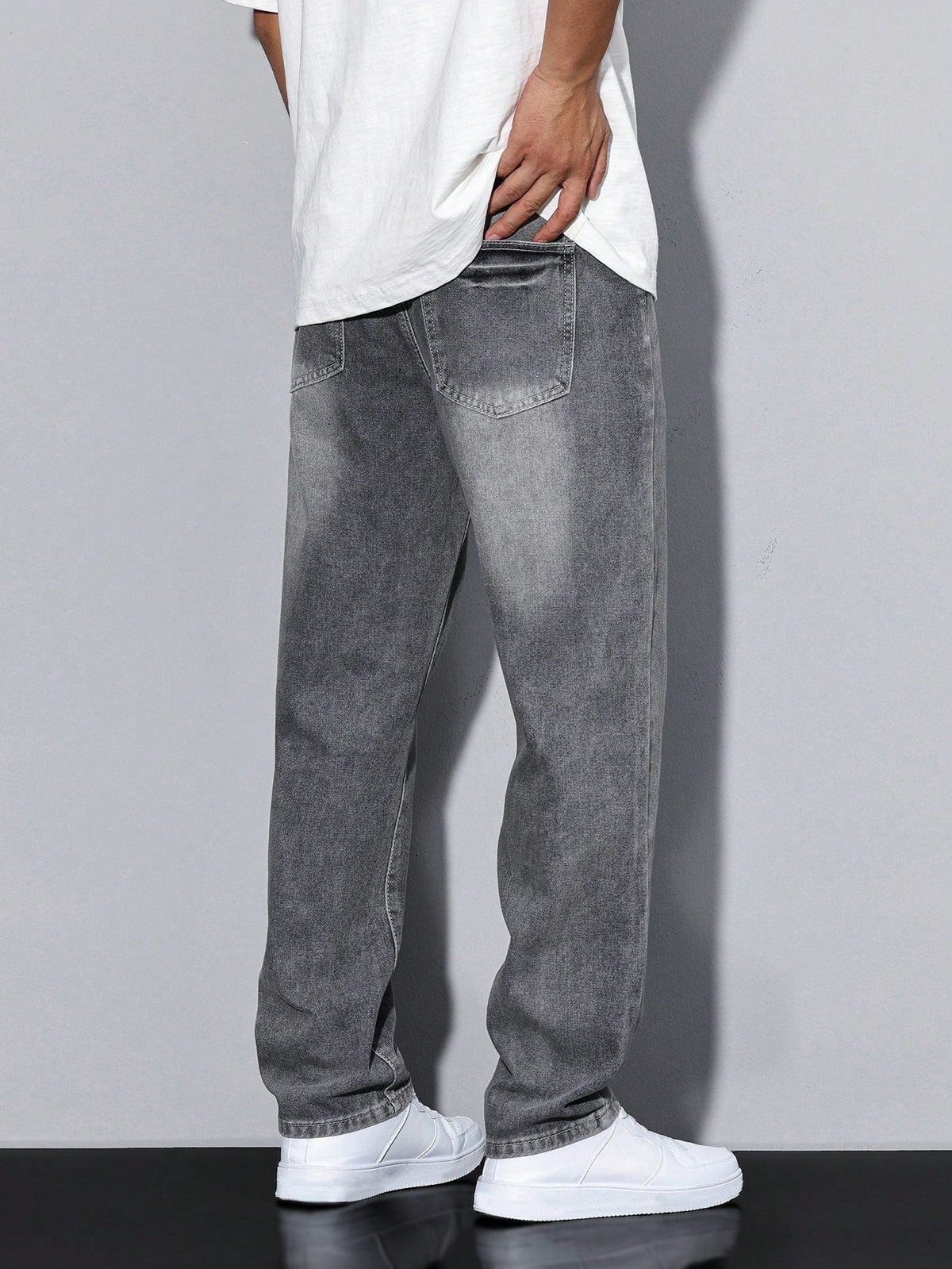 Men's baggy denim jeans by Kate and Wendy with zip fly and five-pocket design, shown hanging on a wooden rack.