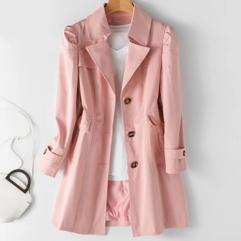 Pink Jack Hafford Novelle trench coat hanging on a wooden hanger, showcasing its stylish design and smooth fabric.