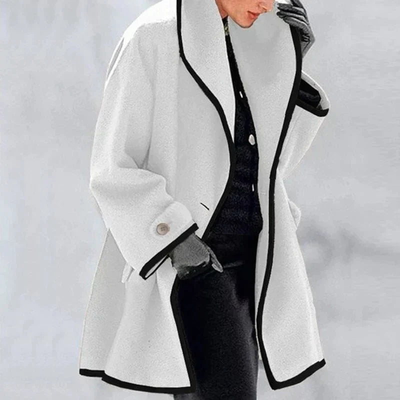 Homixa Agnes women's merino wool trench coat with statement collar, contrast trim, and buttoned cuffs, shown in a stylish profile view.
