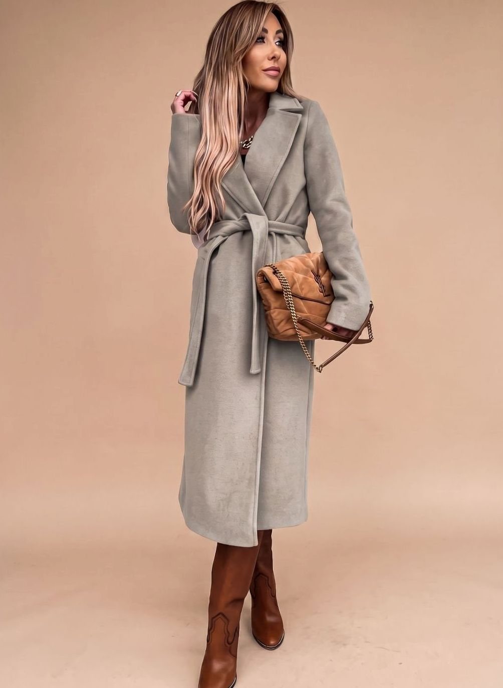 Women's belted knee-length trench coat by Homixa with notched lapels and wool-blend fabric, shown on a model in a stylish outdoor setting.