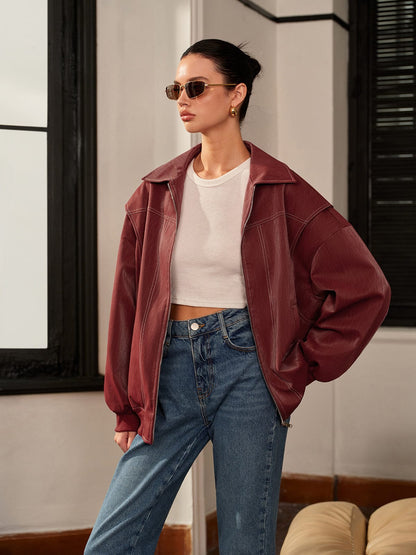 Women's burgundy vegan leather zip-front jacket by Homixa with clean lines and sporty accents, displayed on a hanger.