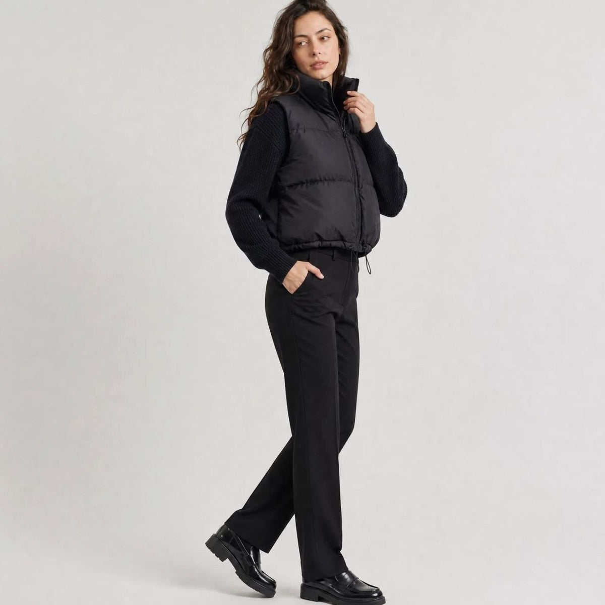 Women's quilted sleeveless puffer vest by Homixa with high collar, zip front, casual cropped design, ideal for layering.