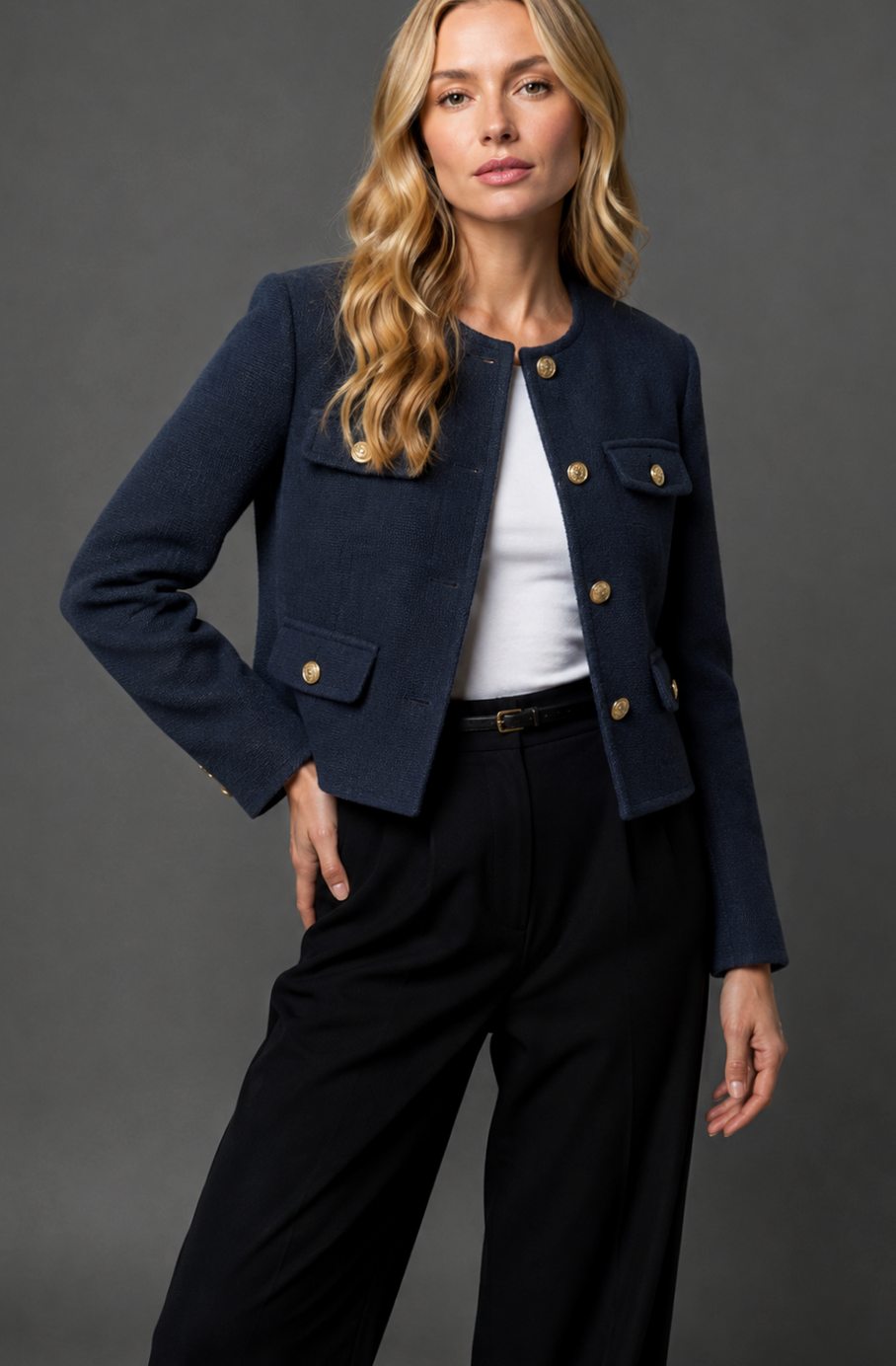 Women's cropped tweed blazer jacket by Homixa with gold buttons and flap pockets, shown on a model.