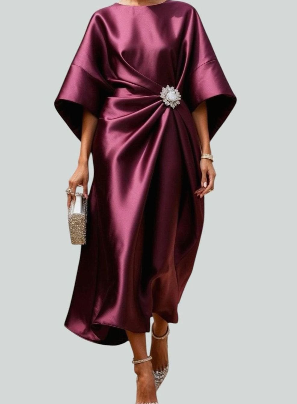 Women's satin midi dress by Homixa featuring draped fabric, batwing sleeves, and a waist brooch, shown in a stylish front view.