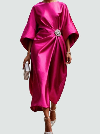 Elegant women's satin midi dress by Homixa featuring draped fabric, batwing sleeves, and a decorative brooch at the waist.