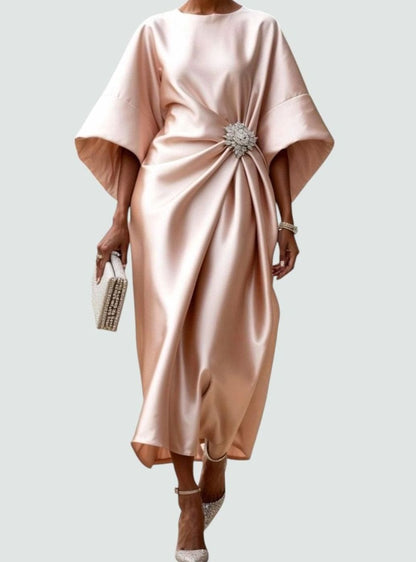 Women's satin midi dress with batwing sleeves and brooch detail, designed by Homixa, featuring a draped elegant silhouette.