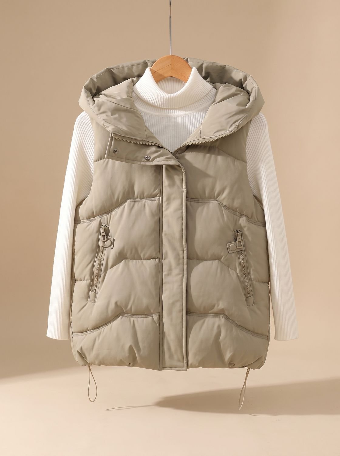 Women's Homixa padded hooded puffer vest with zipper pockets, suitable for fall and winter layering, shown in a neutral color.