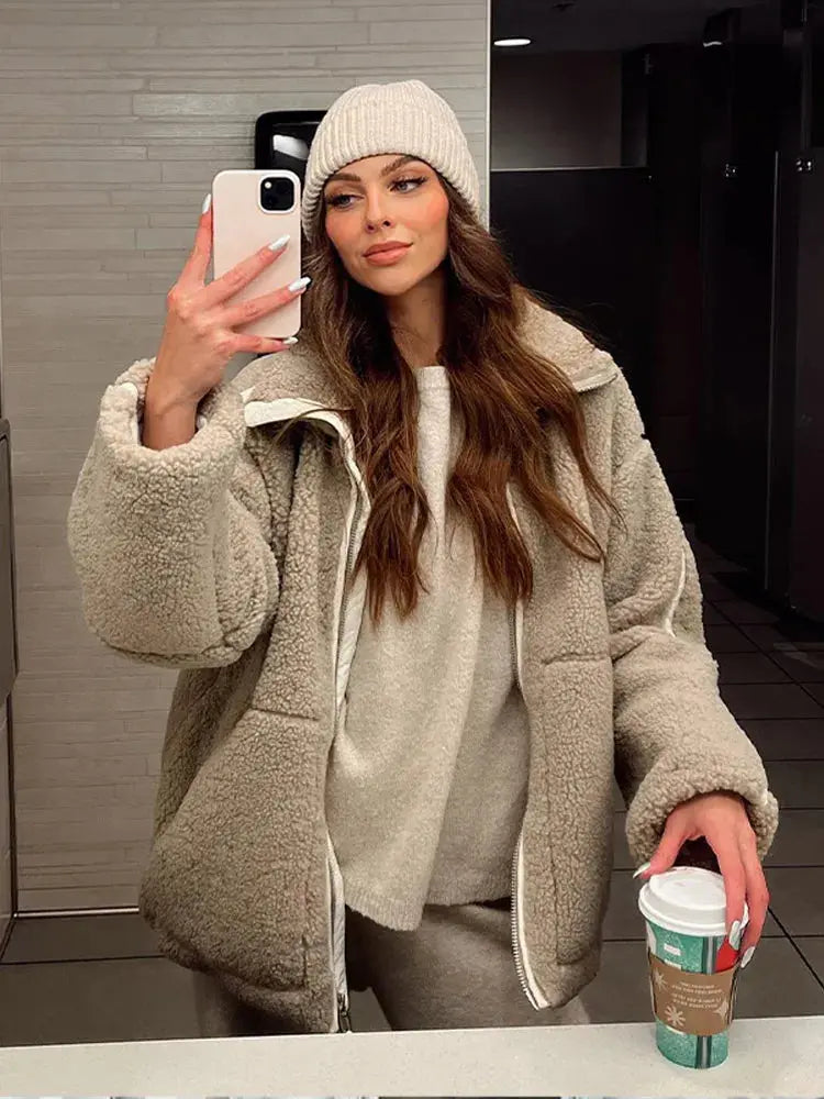 Women’s Homixa faux-fur fleece jacket with high collar, zip front, and patch pockets, shown on a model in a casual outdoor setting.