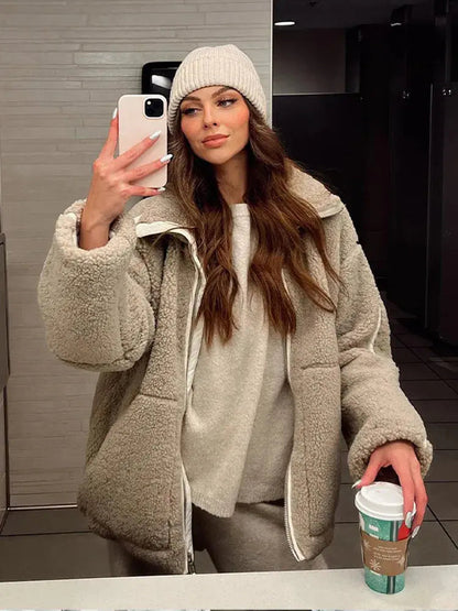 Women’s Homixa faux-fur fleece jacket with high collar, zip front, and patch pockets, shown on a model in a casual outdoor setting.