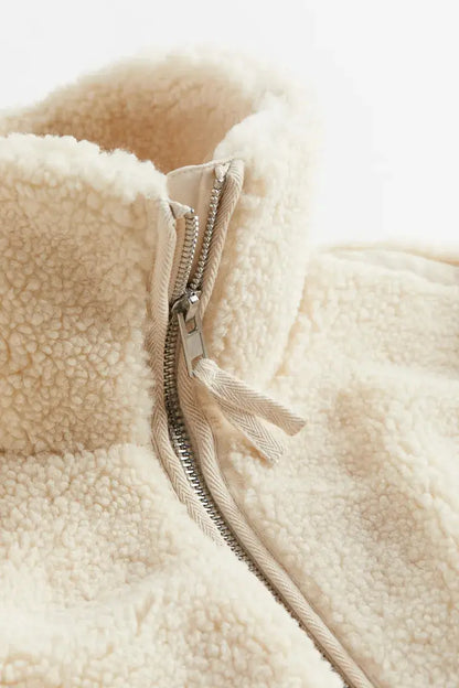 Women’s Homixa faux-fur fleece jacket with high collar, zip front, and patch pockets, shown on a model.