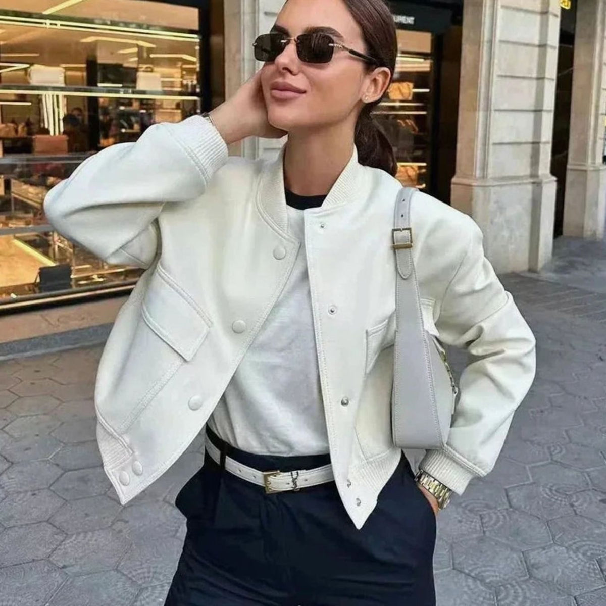 Women’s faux-leather bomber jacket by Homixa featuring snap buttons, patch pockets, and ribbed collar on a model.