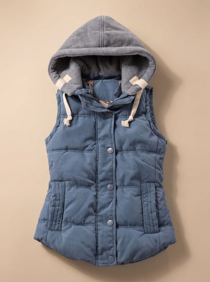 Women's fitted puffer vest by Homixa with quilted fill and a detachable contrast hood, shown in a close-up view.