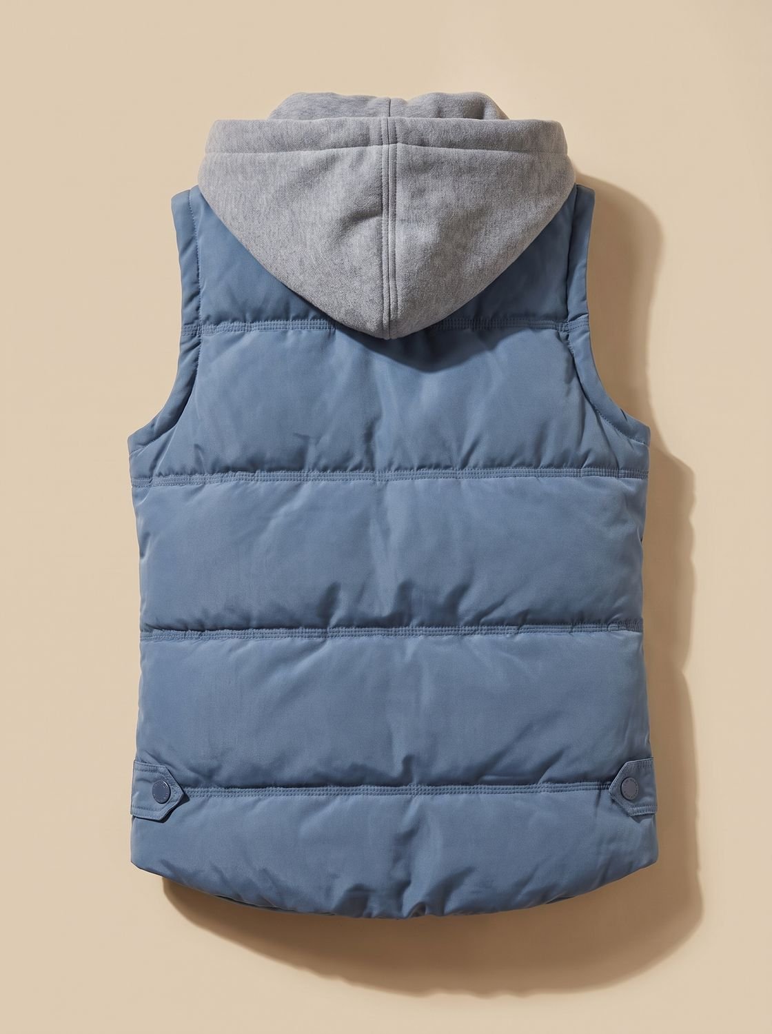 Women's Homixa fitted puffer vest with quilted fill and detachable contrast hood, shown on a model.