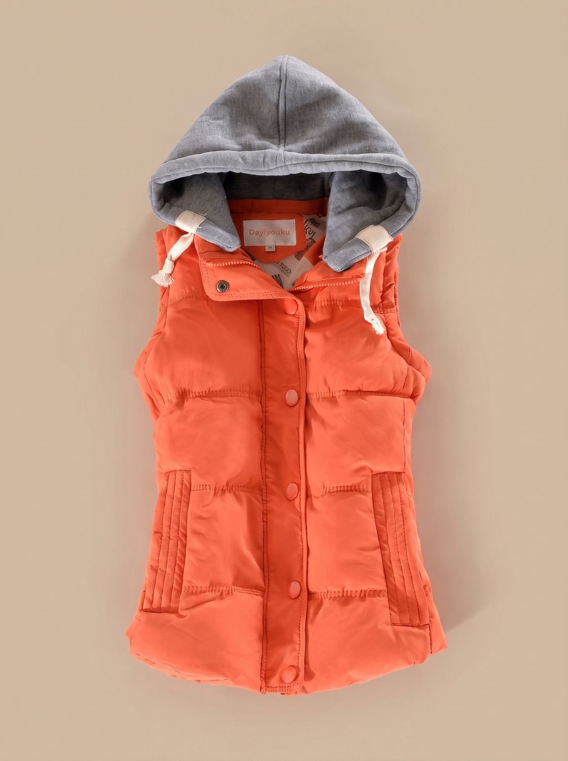 Women's fitted puffer vest by Homixa with quilted fill, hood, and detachable contrast hood, designed for warmth and style.