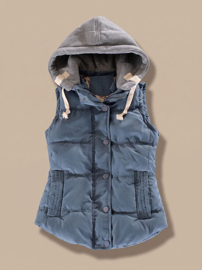 Women’s fitted puffer vest with quilted fill and detachable contrast hood by Homixa, shown on a mannequin.