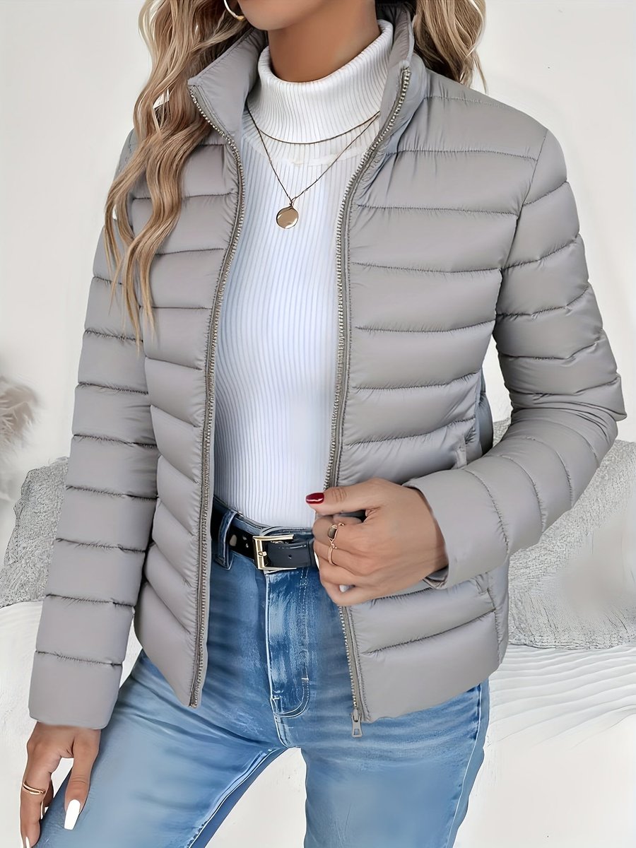 Women's quilted winter jacket by Homixa featuring a full zip, slim fit, and stand collar, shown on a model.