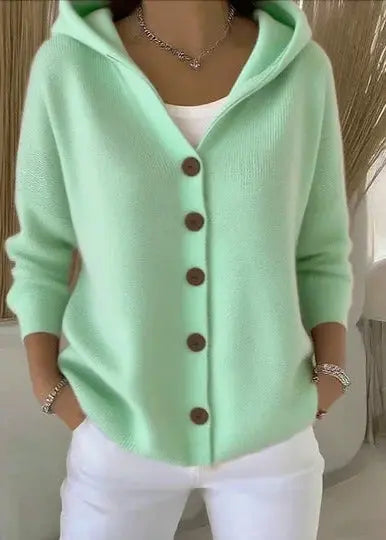 Women's Homixa hooded button-front cardigan with relaxed fit and ribbed hem, shown hanging on a wooden hanger.
