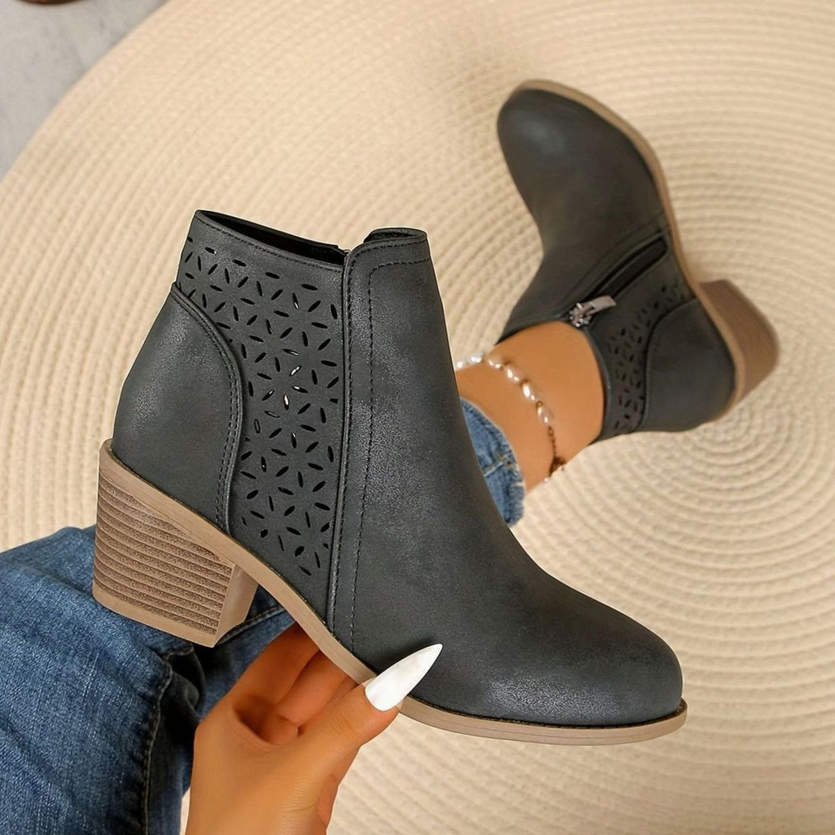 Women's Homixa laser-cut booties with floral cutout detail, block heel, and side zipper, showcasing stylish footwear design.