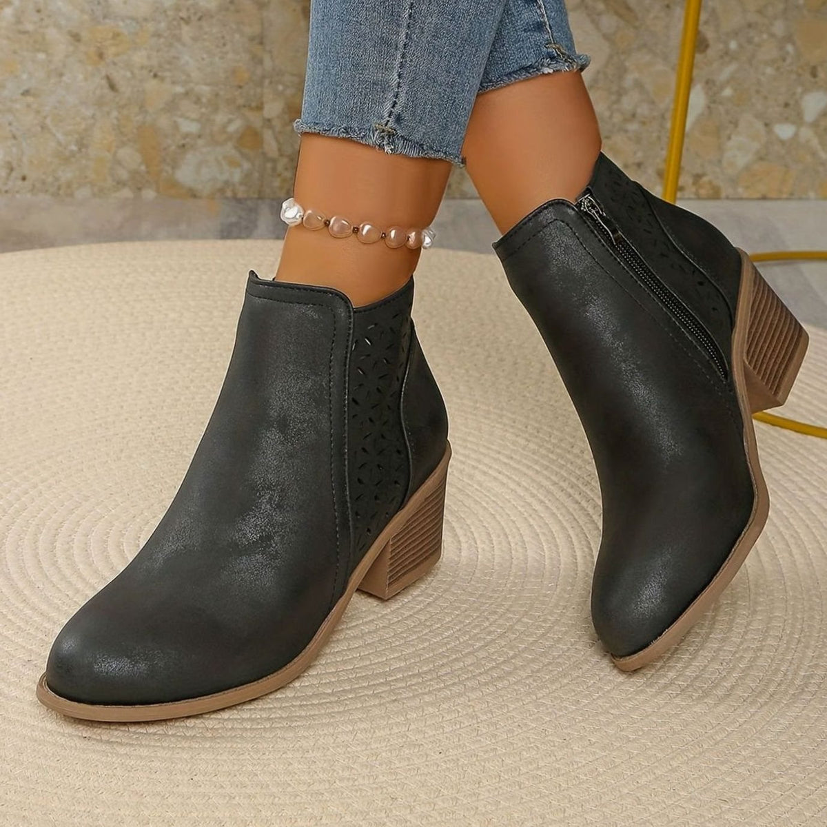 Women's laser-cut booties by Homixa featuring floral cutout details, a block heel, and side zipper for stylish comfort.