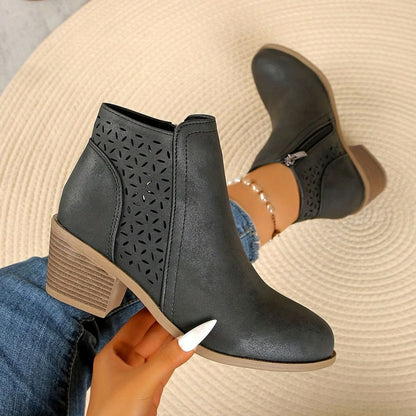Women's laser-cut booties by Homixa with floral cutouts, block heel, and side zipper, showcasing stylish and intricate design details.