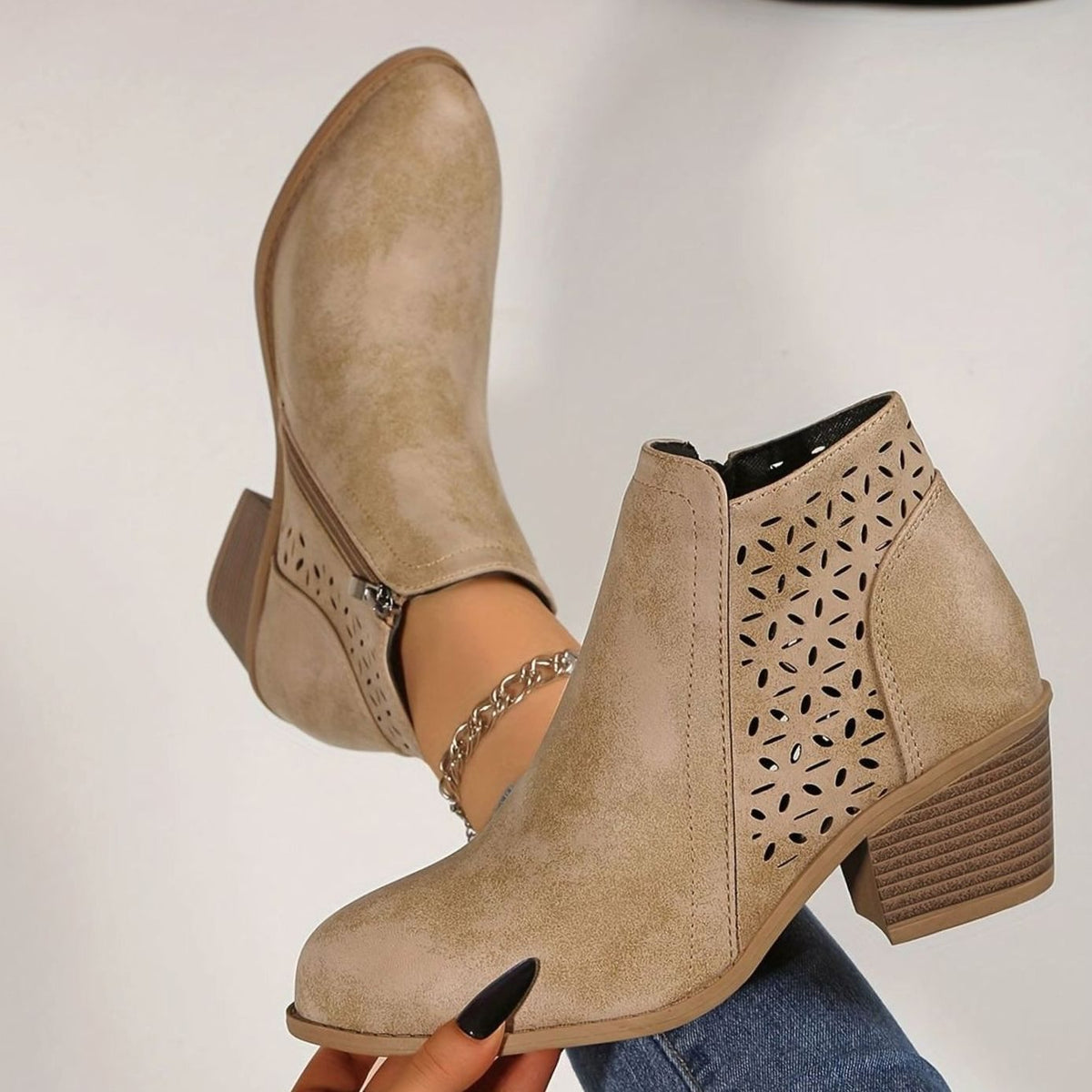 Women's Homixa laser-cut booties with floral cutout design, block heel, and side zipper, showcasing stylish footwear details.