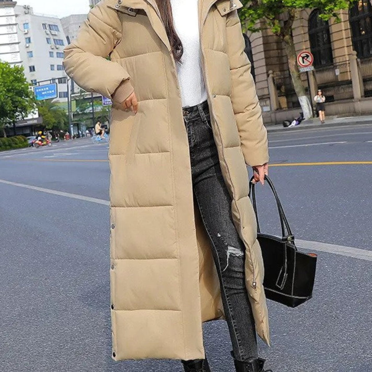 Women’s long quilted winter puffer coat by Homixa with high collar and snap button closures, perfect for cold weather.