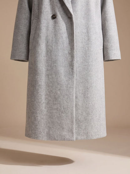 Women's tailored wool coat by Homixa featuring lapels and double-breasted buttons, shown on a model with a classic overcoat fit.