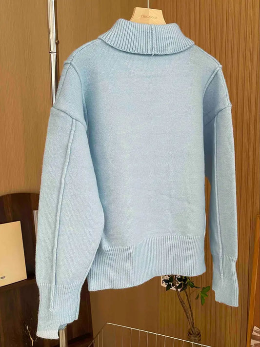 Women's loose-fit knit sweater with stand collar and dropped shoulders, designed by Homixa, shown on a model.