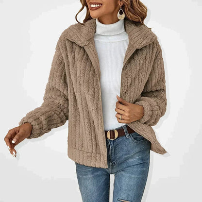 Women's oversized quilted fleece coat by Homixa with zip-up front, ribbed cuffs, and spread collar, shown hanging on a clothing rack.