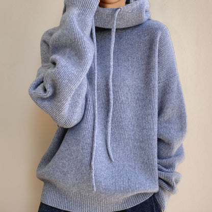 Women's oversized soft-knit sweater by Homixa with hood and adjustable drawstring, displayed on a model.