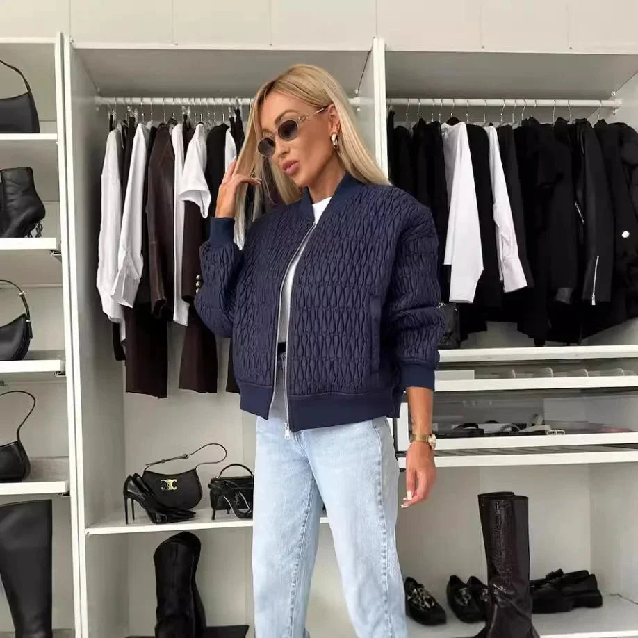 Women's quilted bomber jacket by Homixa with zip-front closure and structured silhouette, displayed on a hanger.