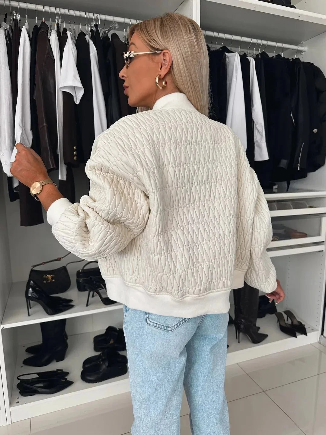 Women's quilted bomber jacket by Homixa with zip-front closure and structured silhouette, shown on a model.