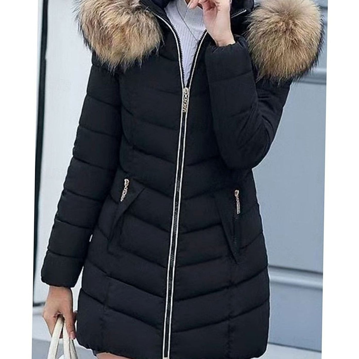 Women's Homixa quilted parka with vegan-fur hood trim, chevron pattern, and gold zippers, showcasing a stylish outerwear design.