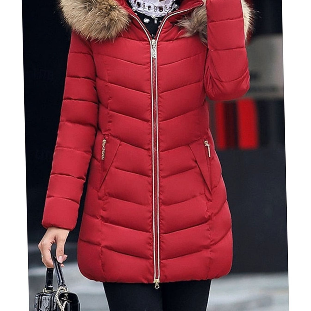 Women's quilted Homixa parka with vegan-fur hood trim, chevron pattern, and gold zippers, shown on a model in a city setting.