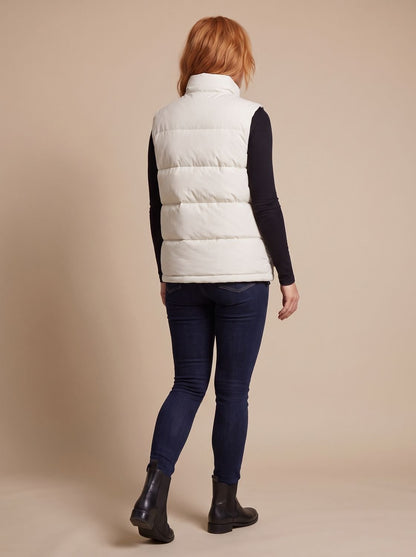 Women's quilted puffer vest with stand collar, flap pockets, and hidden zipper by Homixa, shown on a model.