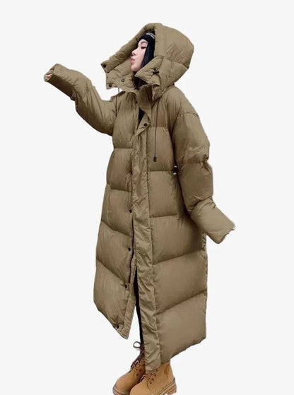 Women’s relaxed-fit long puffer coat by Homixa with side pockets and quilted hood, designed for warmth and comfort.