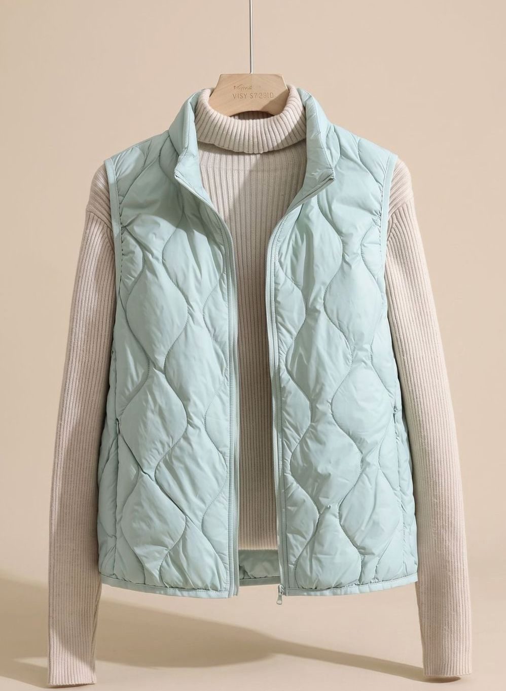 Women's relaxed-fit quilted puffer vest by Homixa with stand collar and warm filling, sleeveless design, ideal for layering.