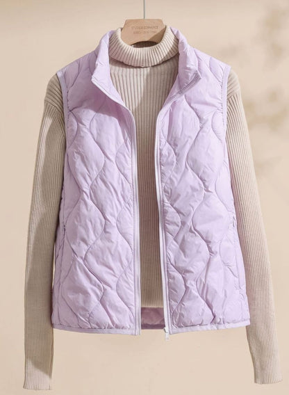 Women's relaxed-fit quilted puffer vest with stand collar and warm filling, by Homixa, shown laid flat with front view.