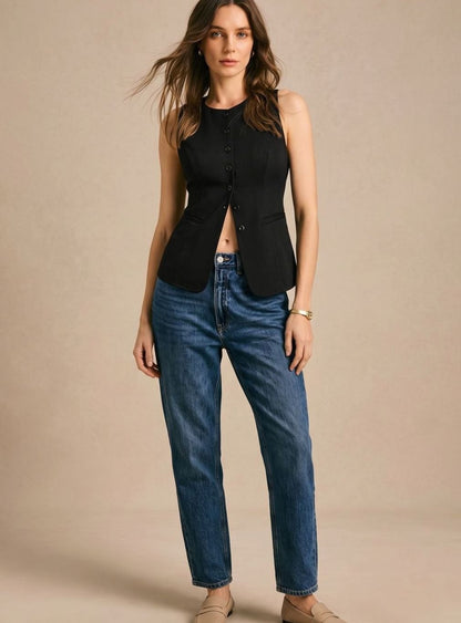 Women's sleeveless button-front vest by Homixa, fitted waist with curved front hem, shown on a model in a casual setting.