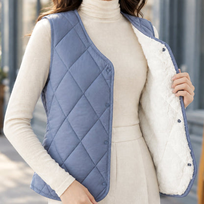 Women's sleeveless diamond-quilted vest by Homixa with sherpa lining and snap front, displayed on a hanger.