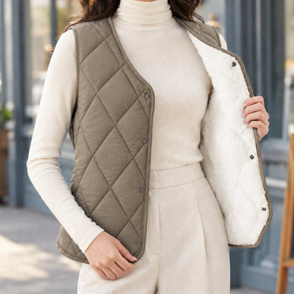 Women's sleeveless diamond-quilted vest by Homixa with sherpa lining and snap front, shown on a model.