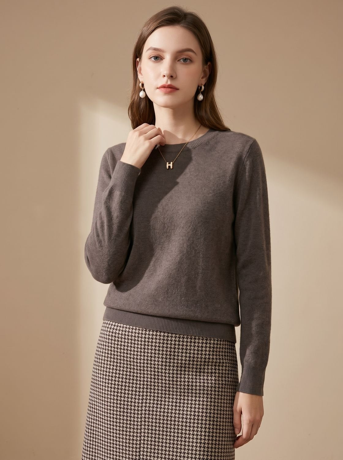 Women's soft cashmere crew-neck sweater with long sleeves and breathable knit, by Homixa, shown on a hanger against a neutral background.